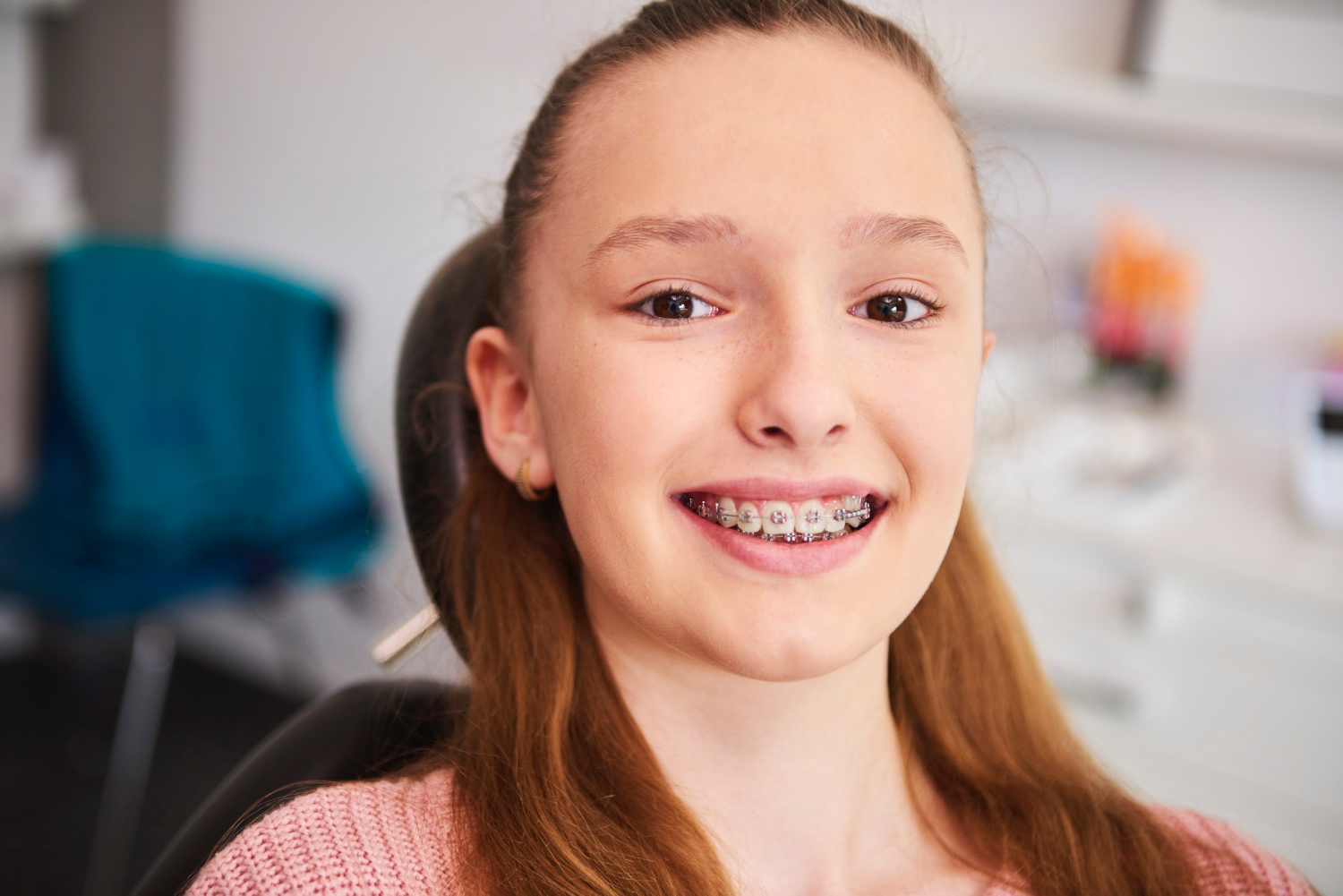 Adolescente sorrindo com aparelho ortodôntico